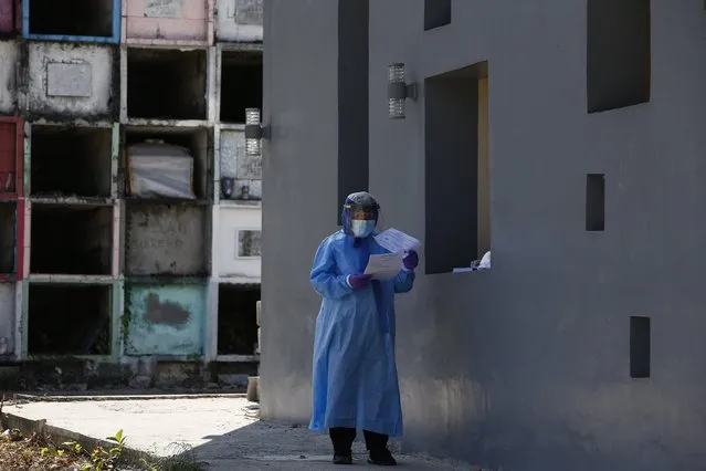 A funeral service worker wearing protective gear reads documents related to a citizen who died while being investigated for COVID-19, at a crematorium specifically dealing with coronavirus cases in Quezon City, Metro Manila, Philippines 25 March 2020. According to Philippine health officials, 552 cases of coronaviruis and COVID-19 have been confirmed in the country, with 35 related deaths. (Photo by Rolex Dela Pena/EPA/EFE)