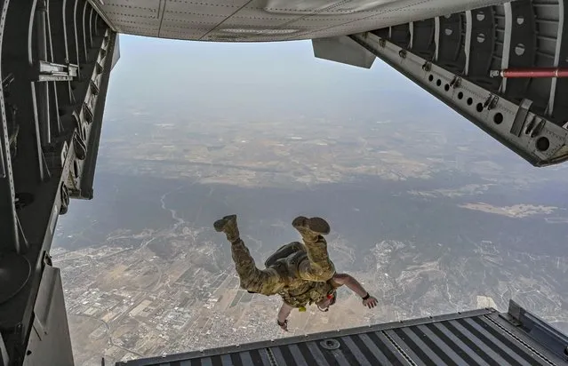 A US Air Force Special Tactics operator assigned to the 352nd Special Operations Wing and members of El Escuadrón de Zapadores Paracaidistas (EZAPAC) execute a military free fall from a Spanish C-295 aircraft near Alcantarilla air base, Spain in July 2022. (Photo by Staff Sgt Izabella Workman/U.S Air Force/CMA)