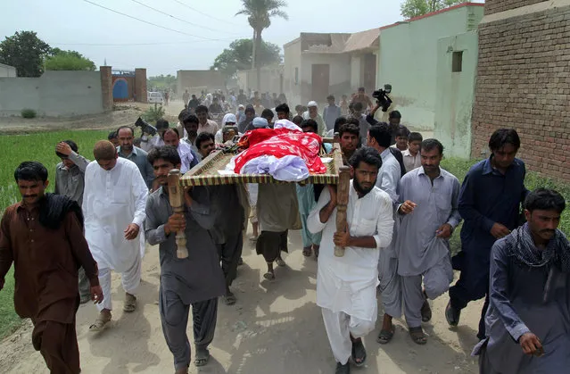 Relatives and local residents carry the coffin of slain model Qandeel Baloch for funeral prayers in Shah Sadar Din village, near Dera Ghazi Khan, Pakistan, Sunday, July 17, 2016. The brother of Baloch confessed to strangling her to death for “family honor” because she posted “shameful” pictures on Facebook. Baloch, who had become a social media celebrity in recent months, stirred controversy by posting pictures online taken with a prominent Muslim cleric. (Photo by Asim Tanveer/AP Photo)