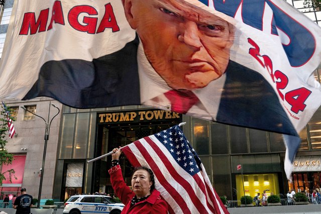 A supporter of former U.S. President Donald Trump holds up a U.S. national flag at Trump Tower in New York City, U.S., October 1, 2023. (Photo by David 'Dee' Delgado/Reuters)
