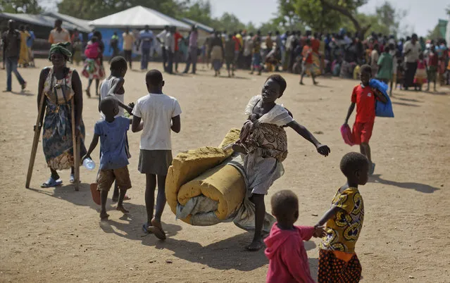In this Friday, June 9, 2017 file photo, a South Sudanese refugee girl with a baby on her back carries a foam mattress to the communal tent where they will sleep, at the Imvepi reception center, where newly arrived refugees are processed before being allocated plots of land in nearby Bidi Bidi refugee settlement, in northern Uganda. International donors are threatening to withdraw funding for Uganda's South Sudanese refugee crisis over allegations that include misuse of relief items and the trafficking of girls and women, a government official said Tuesday, Feb. 6, 2018. (Photo by Ben Curtis/AP Photo)