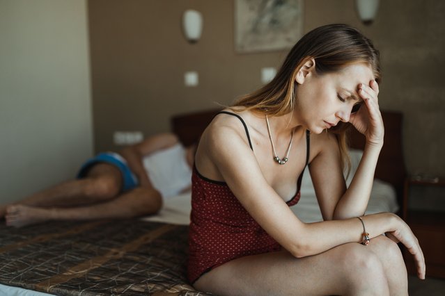 Young woman in pajamas having relationship problems and sitting in bed. (Photo by domoyega/Getty Images)