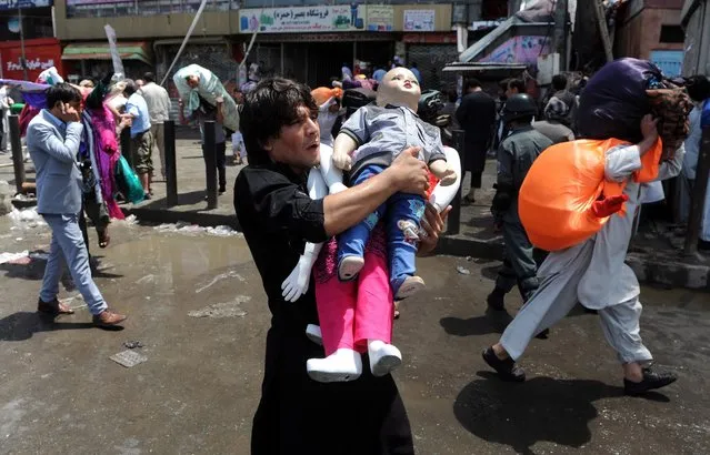 An Afghan man shifts his belonging after fire erupted at a shopping mall, in Kabul, Afghanistan, 04 August 2016. (Photo by Hedayatullah Amid/EPA)