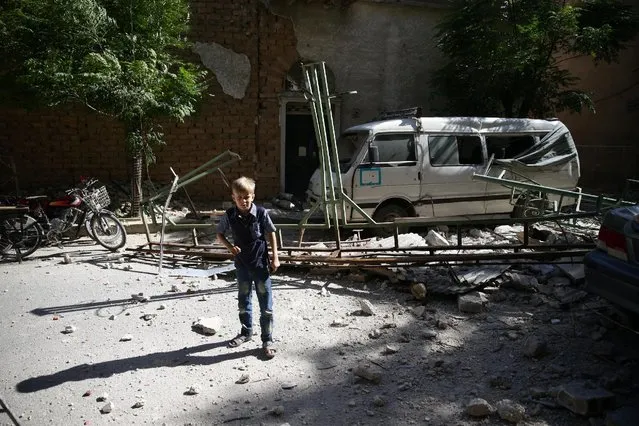 A boy walks amidst the debris of a damaged site after shelling in the rebel held Douma neighborhood of Damascus, Syria July 21, 2016. (Photo by Bassam Khabieh/Reuters)