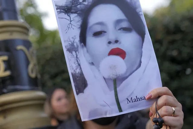 Demonstrators hold placards outside the Iranian Embassy in London, Sunday, September 25, 2022. They were protesting against the death of Iranian Mahsa Amini, a 22-year-old woman who died in Iran while in police custody, who was arrested by Iran's morality police for allegedly violating its strictly-enforced dress code. (Photo by Alastair Grant/AP Photo)