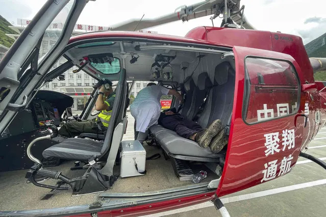 In this photo released by Xinhua News Agency, Gan Yu, a hydropower station worker who had gone missing for 17 days after an earthquake, lies on the backseat of a helicopter after he was found and evacuated to Luding County in southwestern China's Sichuan Province on Wednesday, September 21, 2022 (Photo by Xinhua via AP Photo)