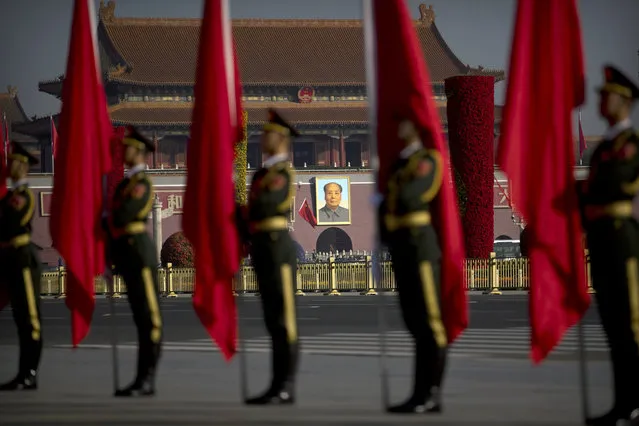 A large portrait of Chinese leader Mao Zedong is seen as Chinese honor guard members stand in formation before a welcome ceremony for Russian Prime Minister Dmitry Medvedev at the Great Hall of the People in Beijing, Wednesday, November 1, 2017. (Photo by Mark Schiefelbein/AP Photo)