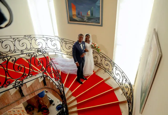 Indat Ange Desire, 30, and Marie Andrea Offoumou, 28, pose on the stairs at their wedding ceremony, following the easing of restrictive measures against the spread of the coronavirus disease (COVID-19), in Abidjan, Ivory Coast on May 15, 2020. (Photo by Luc Gnago/Reuters)