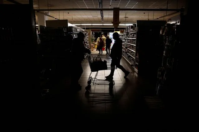 People shop in a supermarket as Kharkiv suffers an electricity outage, amid Russia's attack on Ukraine, in Kharkiv, Ukraine on October 17, 2022. (Photo by Clodagh Kilcoyne/Reuters)