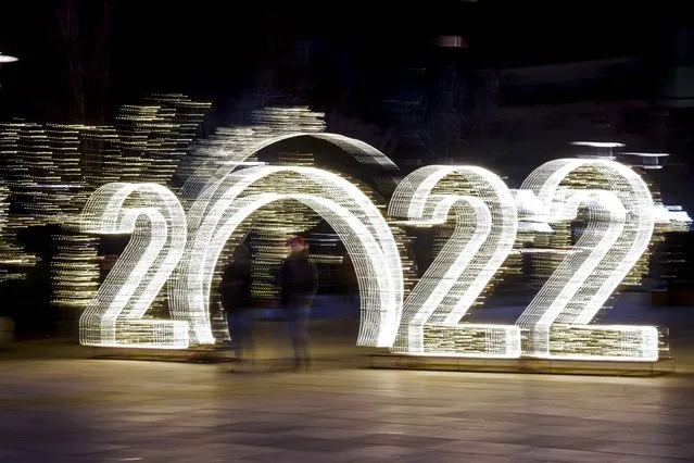 Pedestrians walk in front of a 2022 sign displayed in downtown Pristina on December 30, 2021, ahead of the New Year celebrations in Kosovo. (Photo by Armend Nimani/AFP Photo)