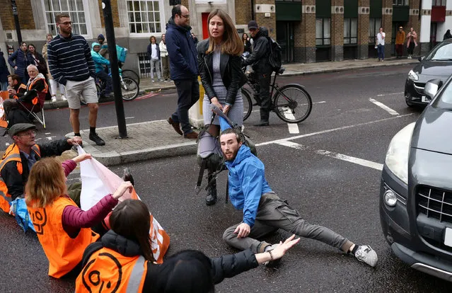 A motorist attempts to drag away activists blocking a road during a “Just Stop Oil” protest in London, Britain, October 30, 2022. (Photo by Henry Nicholls/Reuters)
