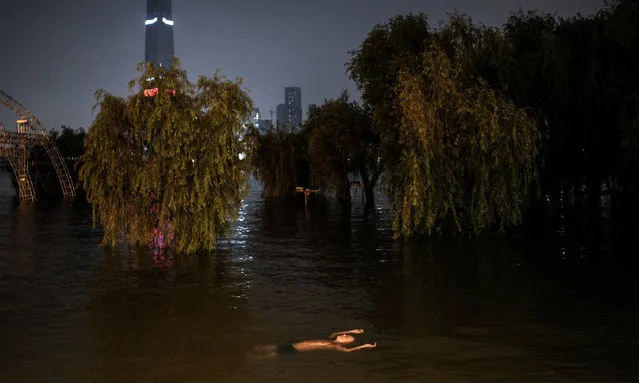 A resident swims in flooded waters at Jiangtan Park caused by heavy rain along the Yangtze river on July 9, 2020 in Wuhan, China. On July 5, Wuhan upgraded its emergency response for flood control from Grade III to Grade II, the second-highest of the four-tier system following weeks of torrential rain which have reportedly left at least 121 dead or missing. (Photo by Getty Images)