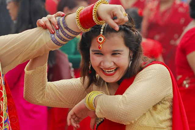 A Nepalese Hindu woman dances during Teej festival at the Pashupatinath Hindu Temple in Kathmandu, Nepal, Sunday, September 4, 2016. During this festival, married Hindu women observe day-long fast and pray for a happy married life while those unmarried pray for a good husband. (Photo by Niranjan Shrestha/AP Photo)