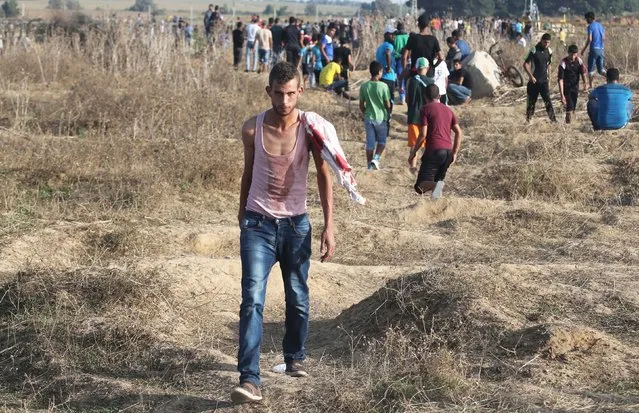 A Palestinian with blood on his clothes leaves the frontline during clashes with Israeli troops near the border between Israel and Central Gaza Strip October 13, 2015. (Photo by Ibraheem Abu Mustafa/Reuters)