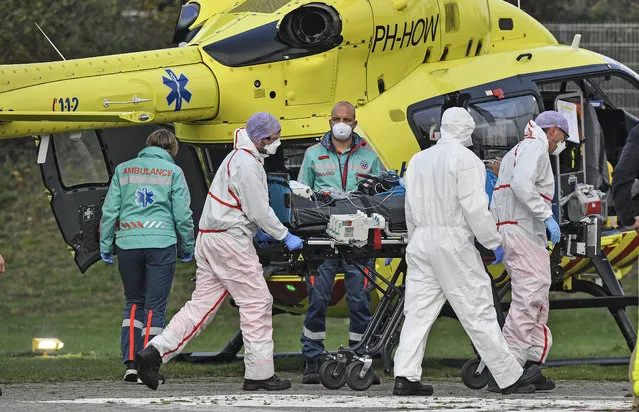 A COVID-19 patient from the Netherlands arrives for treatment by helicopter to the University hospital in Muenster, Germany, Friday, October 23, 2020. The transfer is intended to reduce the coronavirus pressure on the intensive care units in the Netherlands. (Photo by Martin Meissner/AP Photo)