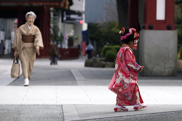 A child in colorful kimono walks at Tokyo's Asakusa district on the occasion of Shichigosan celebration Thursday, October 22, 2020. The festival celebrates children aged three, five and seven for their well-being. (Photo by Eugene Hoshiko/AP Photo)