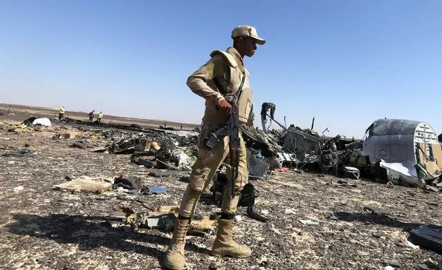 An Egyptian army soldier stands guard near debris from a Russian airliner at its crash siteat the Hassana area in Arish city, north Egypt, November 1, 2015. (Photo by Mohamed Abd El Ghany/Reuters)
