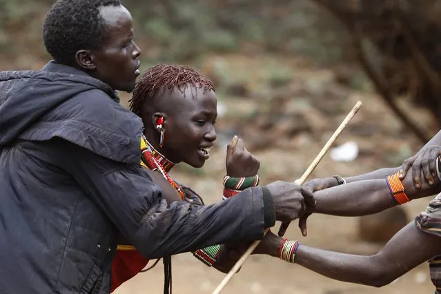 A man and women hold onto a girl as she tries to escape when she realised she is to to be married, about 80 km (50 miles) from the town of Marigat in Baringo County December 7, 2014. (Photo by Siegfried Modola/Reuters)