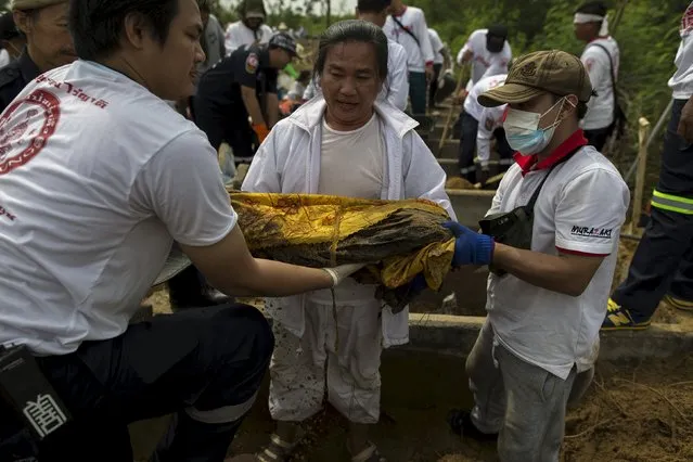 Volunteers carry the remains of unclaimed bodies from a graveyard during a mass exhumation at Poh Teck Tung Foundation Cemetery in Samut Sakhon province, Thailand November 3, 2015. (Photo by Athit Perawongmetha/Reuters)