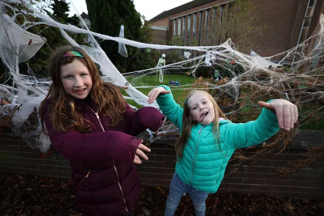 Mollie (right), 7, and Emily, 9 in front of Halloween decorations on houses in Stormont, Belfast on October 27, 2020. (Photo by Liam McBurney/PA Images via Getty Images)