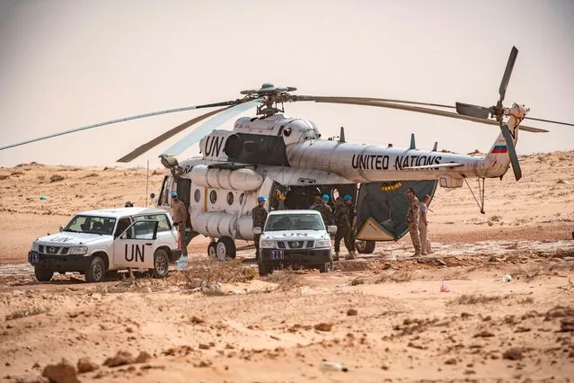 United Nations Mission for the Referendum in Western Sahara (MINURSO) personnel disembark from a Mil Mi-8 helicopter upon landing on the Moroccan side of border crossing point between Morocco and Mauritania in Guerguerat located in the Western Sahara, on November 25, 2020, after the intervention of the royal Moroccan armed forces in the area. Morocco in early November accused the Polisario Front of blocking the key highway for trade with the rest of Africa, and launched a military operation to reopen it. (Photo by Fadel Senna/AFP Photo)