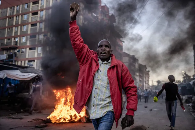 An opposition supporter holds a stone during clashes with Kenya Police Officers at the informal settlement of Mathare in Nairobi, Kenya on March 27, 2023. Kenya's opposition leader Raila Odinga called on his supporters to participate in countrywide protests every Monday and Thursday to demand that President William Ruto lowers the cost of living while questioning last year’s presidential elections results. Kenyans face economic hardship following the government’s recent tax measures and increased food and fuel prices. (Photo by Luis Tato/AFP Photo)