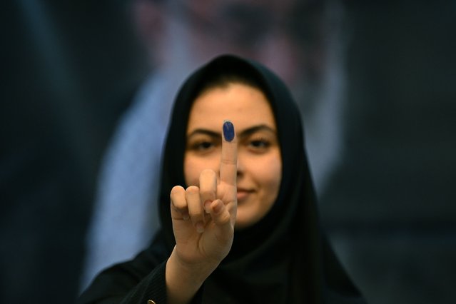 An Iranian national shows her ink marked finger after voting in the presidential election at the Iranian Embassy in Kuwait City on June 28, 2024. Around 61 million Iranians are eligible to vote in the election on June 28, called after the death of ultraconservative president Ebrahim Raisi in a helicopter crash last month. (Photo by Yasser Al-Zayyat/AFP Photo)