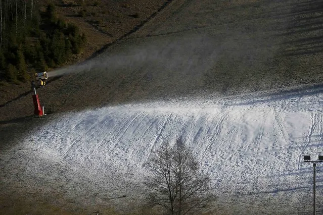 An artificial snow making machine operates on grass-covered slopes at the ski station at Les Gets in the French Alps December 26, 2014. (Photo by Gonzalo Fuentes/Reuters)