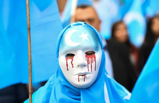 A person wearing a white mask with tears of blood takes part in a protest march of ethnic Uighurs asking for the European Union to call upon China to respect human rights in the Chinese Xinjiang region and ask for the closure of “re-education center” where Uighurs are detained, during a demonstration around the EU institutions in Brussels on April 27, 2018. (Photo by Emmanuel Dunand/AFP Photo)