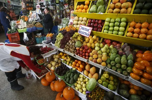 A woman sells fruits at a stand at a market in Lima's Surquillo district, October 23, 2015. (Photo by Mariana Bazo/Reuters)