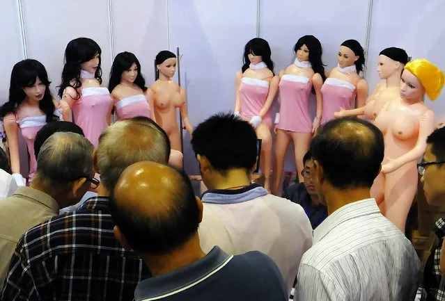 Visitors gather for a closer look at s*x dolls on display at the Guangzhou s*x Culture Festival, in Guangzhou, south China's Guangdong province on November 10, 2013. The annual s*x festival has become legendary in China for its lewd performances, half-naked women, and other bizarre exhibits, will highlight performances from transsexuals for the first time, coupled with the theme Healthy s*x, Happy Families which will include a talk on the psychological and hygienic implications of masturbation. (Photo by AFP Photo/Stringer)
