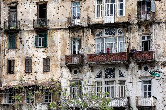 A boy stands in the balcony of a building ravaged by Lebanon's Civil War, in Beirut's southern Shayah district on April 13, 2023. The Lebanese civil war broke out on April 13, 1975 and ended in 1990 with the Taef agreement. (Photo by Anwar Amro/AFP Photo)