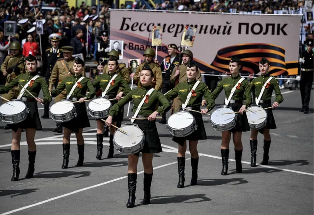 A military band seen as people hold portraits of their relatives who fought in World War II during an Immortal Regiment march on the day of the 73 rdanniversary of the victory over Nazi Germany in the Great Patriotic War of 1941-1945, the Eastern Front of the Second World War in Vladivostok, Russia on May 9, 2018. (Photo by Yuri Smityuk/TASS)