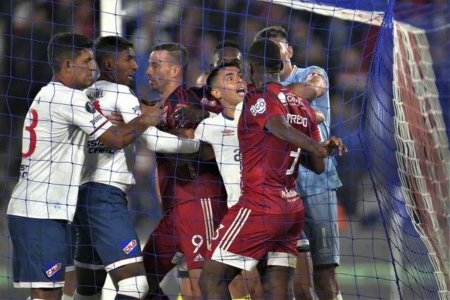 Uruguay's Nacional and Colombia's Independiente Medellin players scuffle under the goal post after Luciano Pons of Independiente Medellin scored his side's equalizer and first goal against Nacional during a Copa Libertadores group B soccer match at Gran Parque Central stadium in Montevideo, Uruguay, Wednesday, April 19, 2023. (Photo by Matilde Campodonico/AP Photo)