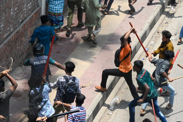 Anti-quota protesters beat a policeman during a clash in Dhaka on July 18, 2024. Bangladesh students vowed on July 18 to continue nationwide protests against civil service hiring rules, rebuffing an olive branch from Prime Minister Sheikh Hasina who pledged justice for seven killed in the demonstrations. (Photo by Munir Uz Zaman/AFP Photo)