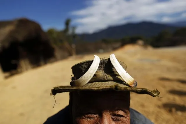 A man who claims to be 100 years old wears a hat adorned with wild boar tusks in Donhe township in the Naga Self-Administered Zone in northwest Myanmar December 30, 2014. Naga men traditionally wore animal parts such as tusks and tiger teeth, although the practice is less common now and younger men usually do so only for festivals. (Photo by Soe Zeya Tun/Reuters)