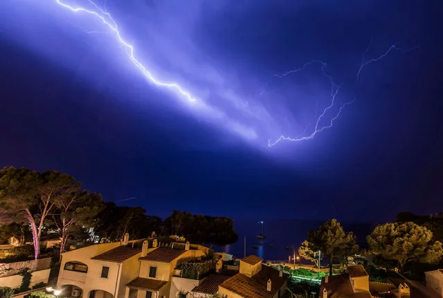 Lightning lights up the village of Sant Elm during a thunderstorm in Majorca, Balearic Islands, Spain, 03 August 2017. Temperatures up to 40 degrees Celsius are expected in the region. (Photo by Cati Cladera/EPA)