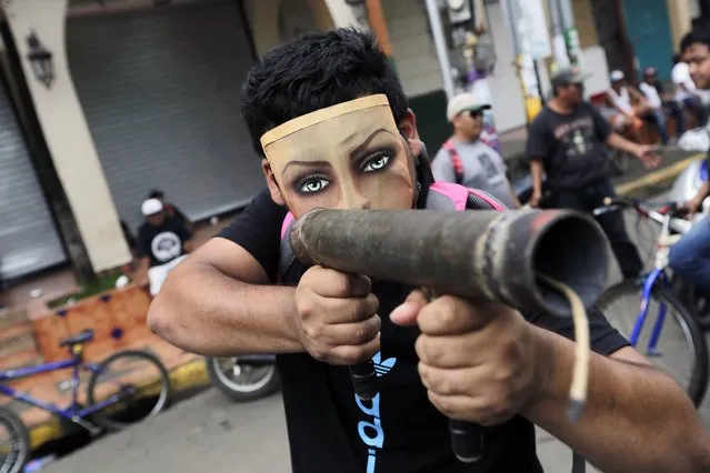 A demonstrator wearing a mask points homemade mortar during a protest in Masaya, Nicaragua on May 28, 2018. (Photo by Inti Ocon/AFP Photo)
