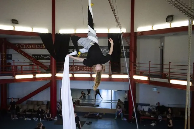 A Ukrainian circus artist who fled the war in Ukraine trains in a circus practice facility in Budapest, Hungary, Tuesday, March 22, 2022. Around 100 Ukrainian circus art students aged 5-20, with their adult chaperones, escaped the embattled cities of Kharkiv and Kyiv amid Russian bombings. In neighboring Hungary, fellow circus devotees extended help and solidarity, taking them in and allowing them to continue training in the safety of the capital, Budapest. (Photo by Anna Szilagyi/AP Photo)