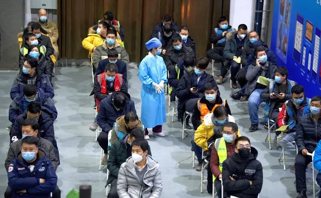 People wait on chairs after being inoculated with a Covid-19 vaccine at the Chaoyang Museum of Urban Planning in Beijing on January 15, 2021. (Photo by Noel Celis/AFP Photo)