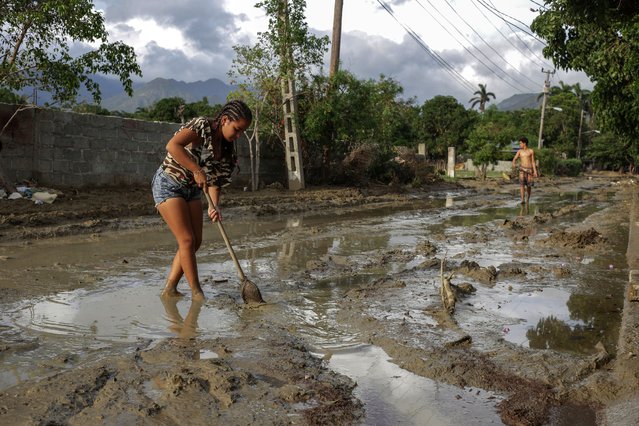 People try to remove mud from a street a week after Hurricane Oscar hit the town of Imias in Guantanamo province, Cuba, Tuesday, October 29, 2024. (Photo by Ariel Ley/Pool via AP Photo)