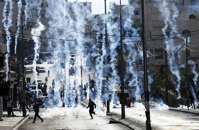 An Israeli borderpolice vehicle shoots tear gas at Palestinians during clashes on the outskirts of the West Bank city of Bethlehem, December 18, 2015. (Photo by Abed Al Hashlamoun/EPA)