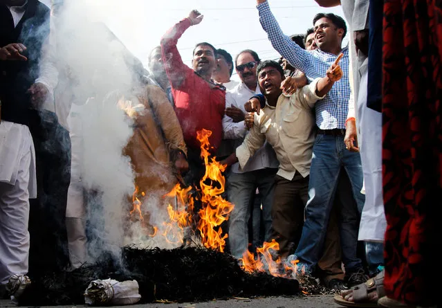 Protesters from India’s main opposition Congress party shout slogans as they burn an effigy of India’s Prime Minister Narendra Modi during a protest against the government's decision to withdraw 500 and 1000 Indian rupee banknotes from circulation, according to a media release, in Ajmer, India, November 17, 2016. (Photo by Himanshu Sharma/Reuters)