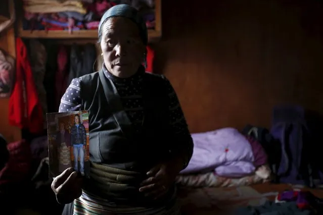 Chamchi Phuti Sherpa, mother of Lakpa Sherpa, who was among the 16 sherpas who died in the avalanche on April 18, 2014, shows a picture of her deceased son at her house in Khumjung, a typical Sherpa village in Solukhumbu District also known as the Everest region, in this picture taken November 30, 2015. (Photo by Navesh Chitrakar/Reuters)