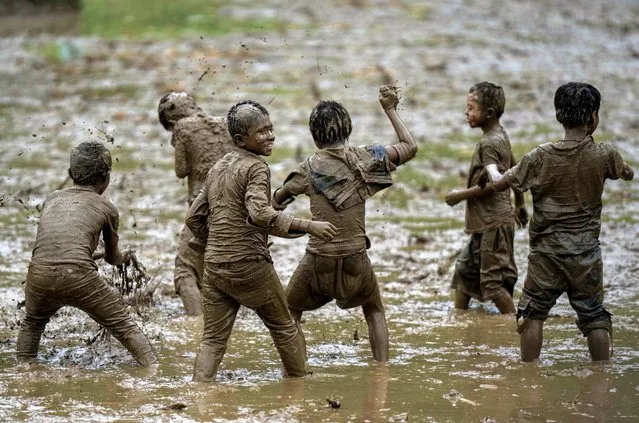 Children play in the mud in a paddy field during Asar Pandra, or paddy planting day at Bahunbesi, Nuwakot District, 30 miles North from Kathmandu, Nepal, Friday, June 30, 2023. (Photo by Niranjan Shrestha/AP Photo)