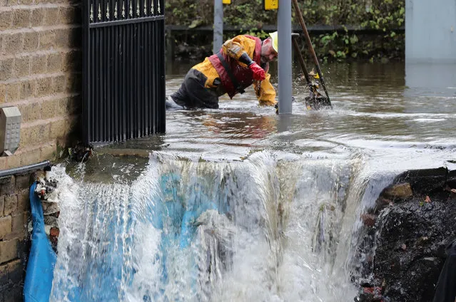 Council workers try to clear drains outside homes hit by fast flowing water last night on November 22, 2016 in Stalybrdge, England. In the wake of Storm Angus torrential rain brought flooding and power cuts to thousands of homes across Britain with emergency services working through the night to help victims of the floods. (Photo by Christopher Furlong/Getty Images)