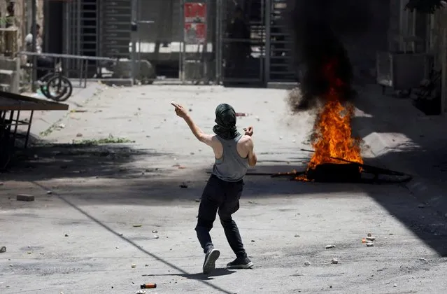 A Palestinian man throws stones during clashes over an Israeli military operation in Jenin, in Hebron, in the Israeli-occupied West Bank on July 4, 2023. (Photo by Mussa Qawasma/Reuters)