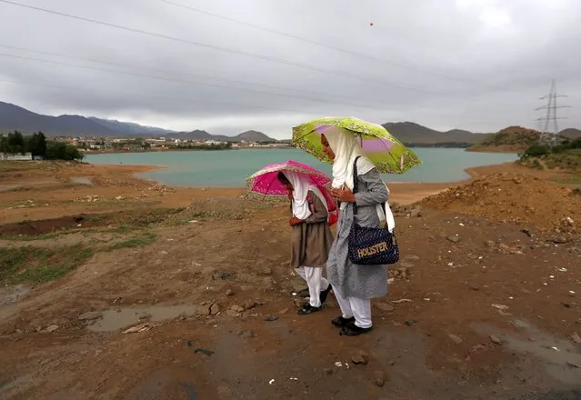 Afghan school girls hold umbrellas to shelter from rain on outskirt of Kabul, Afghanistan on May 15, 2017. (Photo by Mohammad Ismail/Reuters)