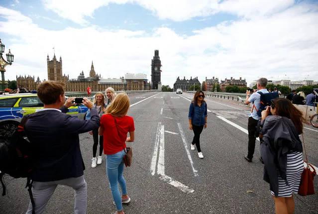 Tourists pose for a picture at a police cordon on Westminster Bridge after a car crashed outside the Houses of Parliament in Westminster, London, Britain, August 14, 2018. (Photo by Henry Nicholls/Reuters)