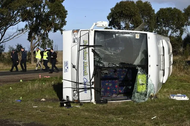 Investigators work at the scene of a bus crash near in Melbourne, Wednesday, May 17, 2023. Seven children remain hospitalized with serious injuries after a truck struck a school bus Tuesday carrying as many as 45 students on the outskirts of Melbourne in southeastern Australia. (Photo by Joel Carrett/AAP Image via AP Photo)
